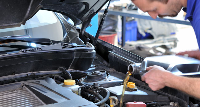 Man pouring engine oil into engine